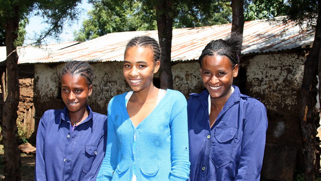 Ihre Zukunft hängt von Bildung ab: Gente Tulu (rechts) und zwei ihrer Mitschülerinnen tragen gerne die blaue Schuluniform. Foto: Kläne